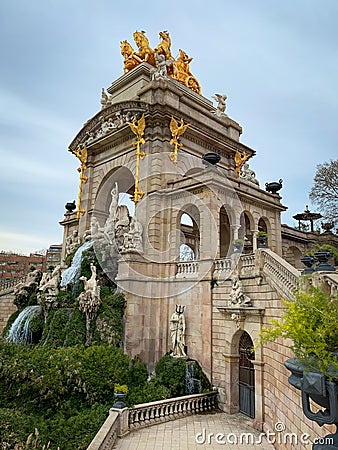 Water cascade and stone monument with an arch and golden statues at Ciutadella Park Stock Photo