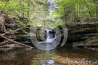 Cascading Beauty: A Small Pennsylvania Waterfall Split by a Majestic Rock Stock Photo