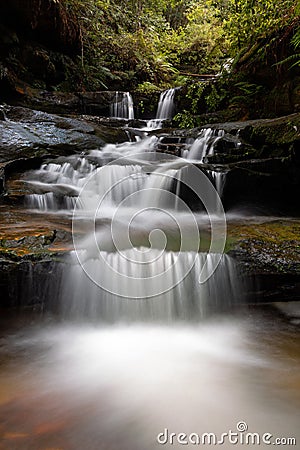 Cascading water through gully into little rock pool Stock Photo