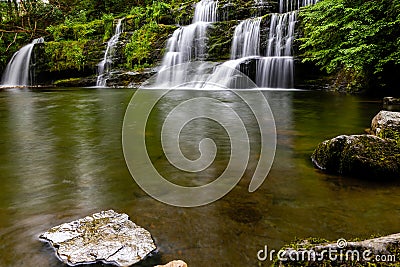 Cascading waterfall in a lush green forest (Sgwd y Pannwr, Wales Stock Photo