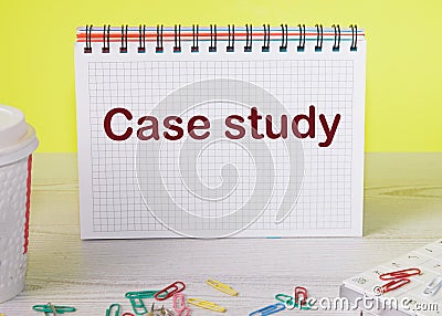 A case study written on a checkered notebook on a yellow background Stock Photo