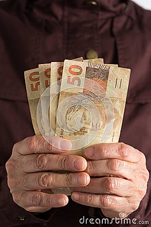 Cash bills from brazilian currency. Old retired person paying in cash Stock Photo