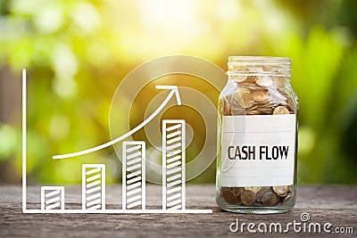 Cash Flow Word With Coin In Glass Jar and graph up. Financial Co Stock Photo