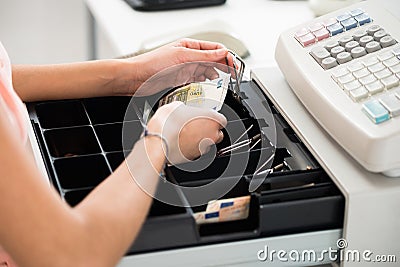 Cashier Searching For Change In Cash Register Drawer Stock Photo