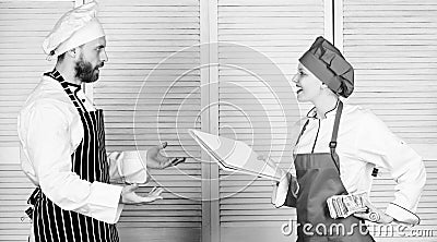 Cashing up. Cook helper giving cooking worksheet to chef. Master cook and helper holding account book and cash money Stock Photo