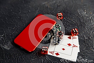 Casino play online concept. Playing chips, cards, three red dices and smartphone Stock Photo