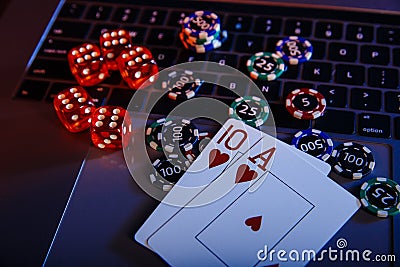 Casino play online theme. Playing chips, cards and dices on laptop close-up Stock Photo