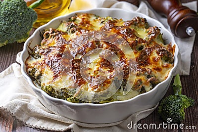 Casserole Cauliflower and broccoli baked with cheese sauce in a pot close-up on a wooden table. Horizontal top view from above. Stock Photo