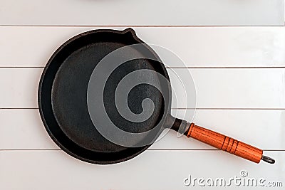 A cast iron frying pan over the background of whiteboards Stock Photo