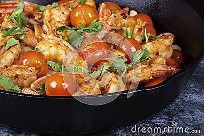 Cast Iron Pan Filled with Cooked Shrimps, Cherry Tomatoes, White Beans, Garnished with Cilantro #2 Stock Photo