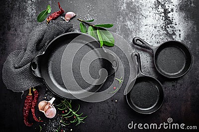 Cast iron pan and spices on black metal culinary background Stock Photo