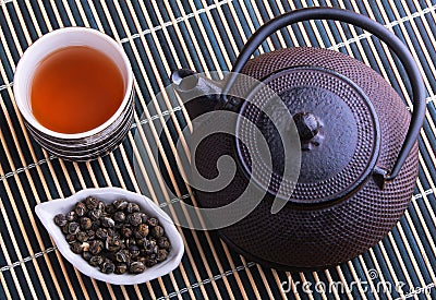 Cast iron TeaPot with teacup and tea leaves Stock Photo