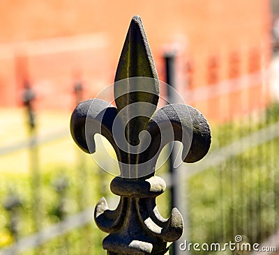 A fleur de lis crowning a wrought iron fence. Stock Photo