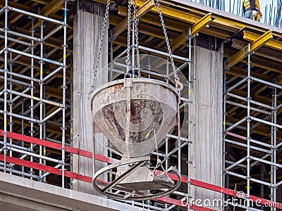 Cast-in-place concrete. Crane lifting concrete container on construction site. Construction of buildings. Tank with Stock Photo