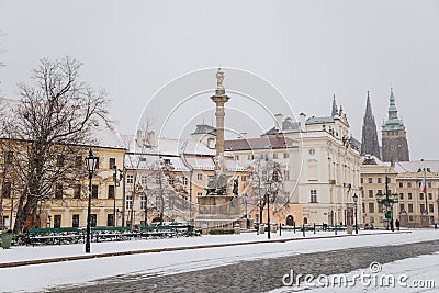 Castle from Hradcany Square, spiers of st Vitus cathedral, archbishop`s palace and Marian Plague Column, snow in winter day, Editorial Stock Photo