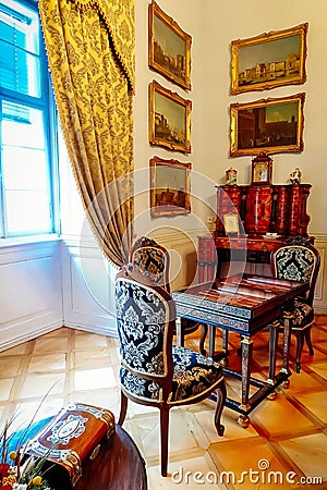 Castle interior. Antique carved furniture, table and chairs. Paintings on the walls. Renaissance castle Horsovsky Tyn, Czech Editorial Stock Photo