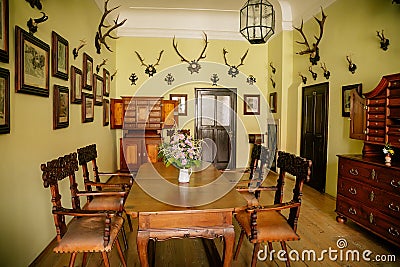 Castle interior, Baroque and renaissance furniture, bureau with swing doors, wooden carved table and chairs, hunting salon with Editorial Stock Photo