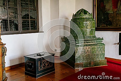 Castle interior, Retro style room with wood carved baroque and renaissance furniture, antique green ceramic tiled stove and large Editorial Stock Photo