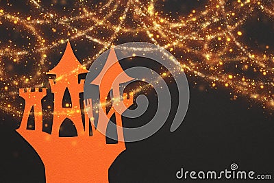 Castle over black paper background and glowing golden lights. Stock Photo