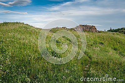 Castle ruins abandoned in the infinite beauty of the expansive green. Stock Photo