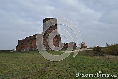 Castle ruins in KoÅ‚o. Destroyed towers and defensive walls made of red brick on the bank of the Warta River Stock Photo