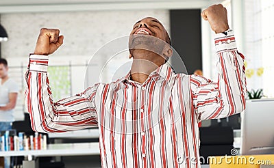 Casual black man celebrating success at office Stock Photo