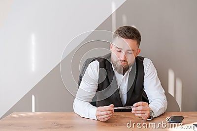 Casual business man bearded, sitting at table with pen in his hand, thinking Stock Photo