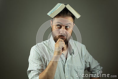 Casual business man with a book using education to overcome business challenges Stock Photo