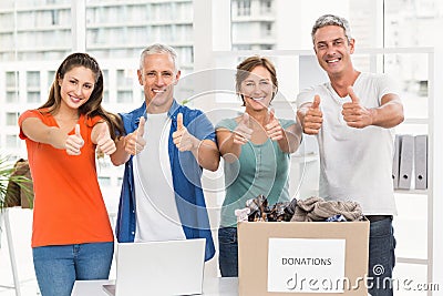 Casual business people donating and doing thumbs up Stock Photo