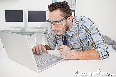 Casual businessman at his desk working on laptop Stock Photo