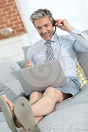 Casual businessman with laptop working on sofa Stock Photo