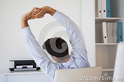 Casual businessman stretching in swivel chair Stock Photo