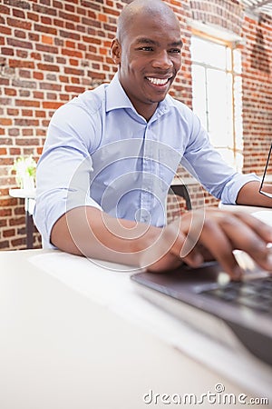 Casual businessman using his laptop at desk Stock Photo