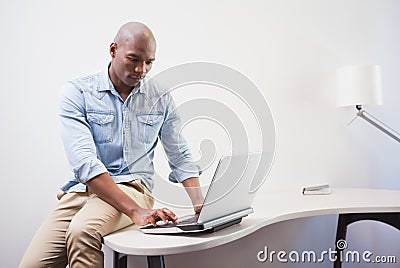 Casual businessman using his laptop at desk Stock Photo