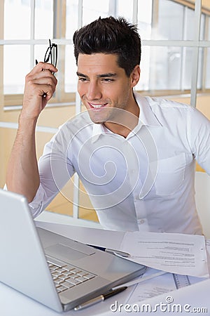Casual businessman using his laptop at his desk Stock Photo