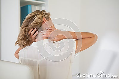 Casual businesswoman rubbing her neck Stock Photo