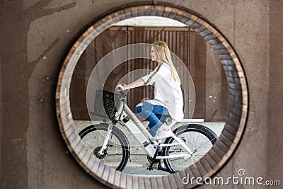 Casual caucasian teenager riding urban electric bicycle in urban environment. Urban mobility concept Stock Photo