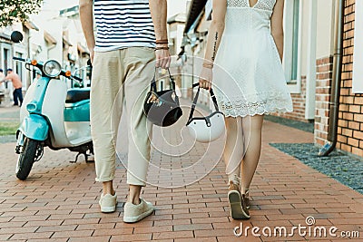 Casual couple holding helmets while walking together outdoors Stock Photo