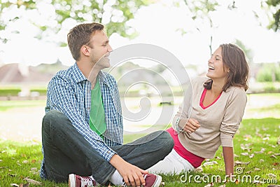 Casual laughing students sitting on the grass Stock Photo