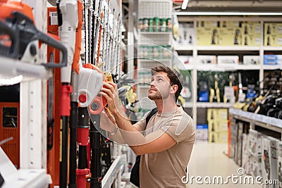 Guy shopping in store of power tools Stock Photo