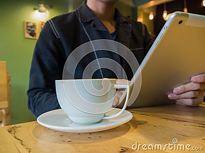 Casual man relaxed using digital tablet with coffee cup Stock Photo