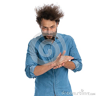 Casual man rubbing his palms and making a diabolical plan Stock Photo