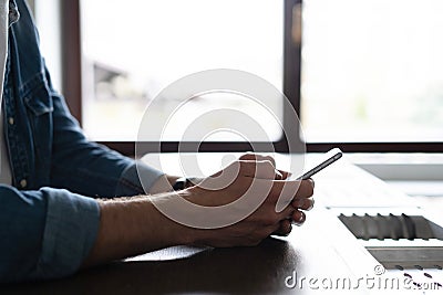 Casual man using smartphone at home kitchen, young man browsing on smart phone in interior, e-business. Stock Photo