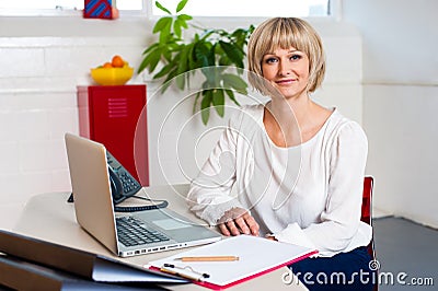 Casual portrait of a woman seated at her work place Stock Photo