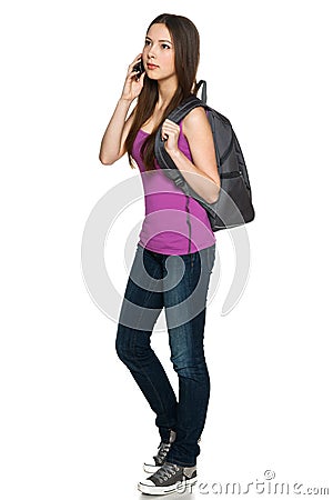 Casual teen girl wearing backpack talking on cell phone Stock Photo