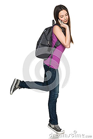 Casual teen girl wearing backpack talking on cell phone Stock Photo