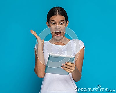 Casual woman is happily surprised about something on his tablet Stock Photo