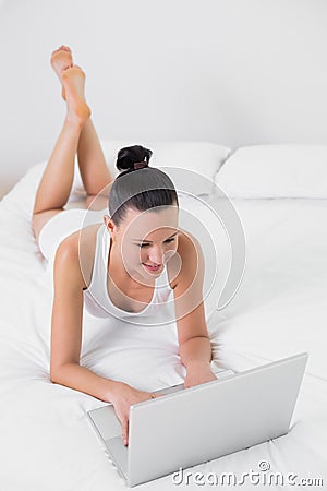 Casual woman using laptop in bed Stock Photo