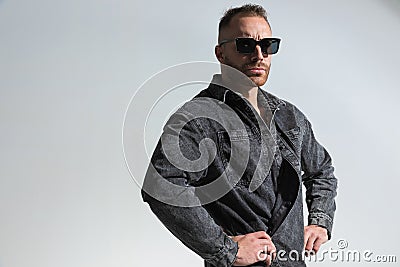 Casual young man posing in a funny way while wearing grey denim jacket Stock Photo