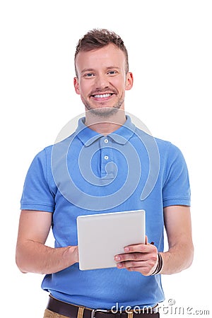 Casual young man smiles while holding tablet Stock Photo